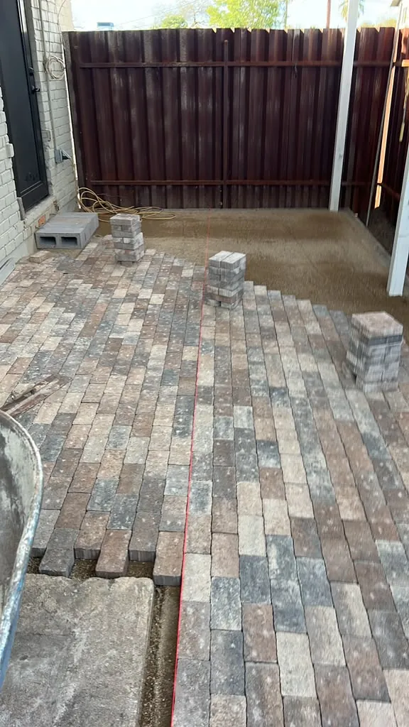 Finished paver patio in multi-tone brick against the block wall