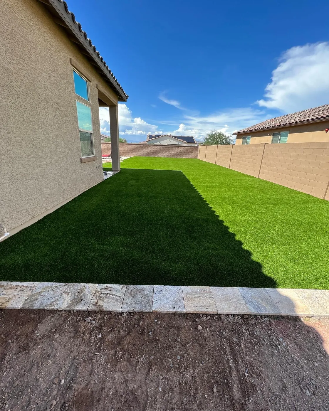 New turf and a young tree, edged in rock.